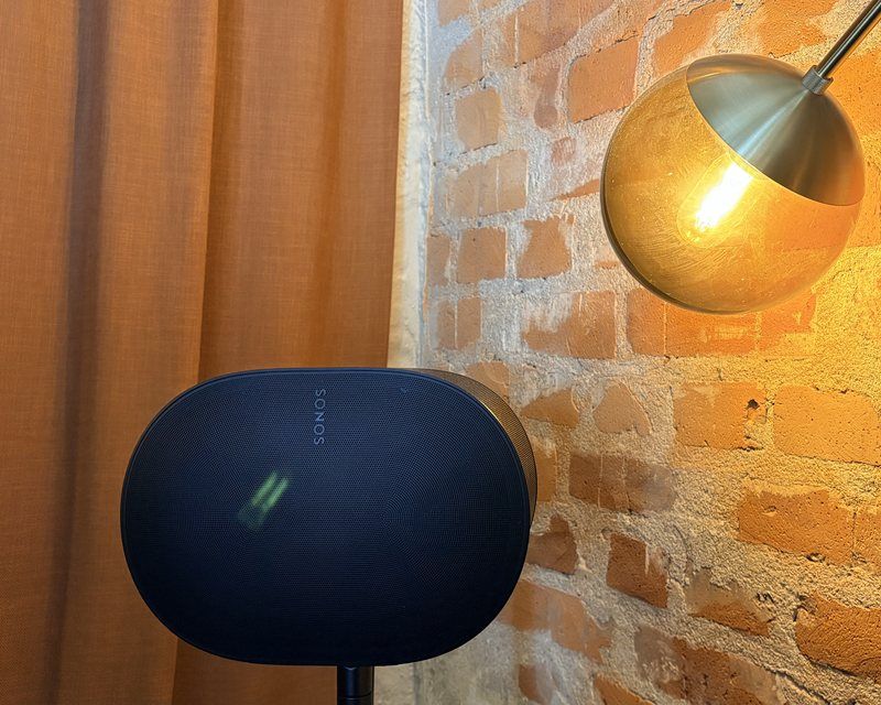 Sonos-högtalare i en företagslokal med tegelvägg och varm belysning